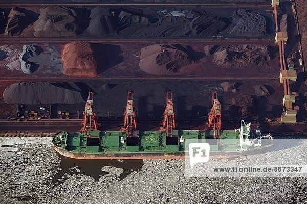 'Ore being loaded onto a freight ship  ''Genco Maximus'' bulk carrier on the Elbe river  Hansaport harbour  Hamburg  Germany'