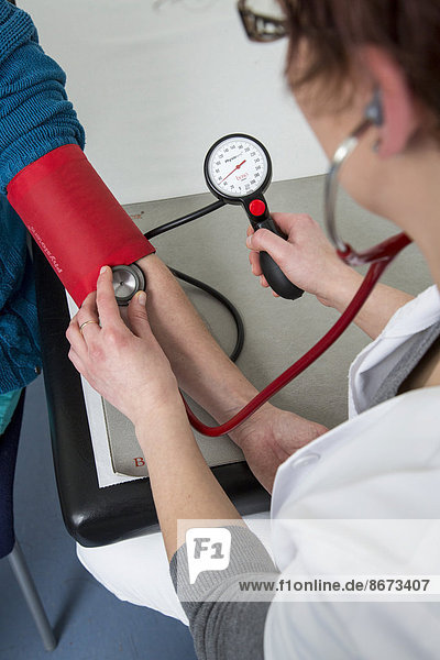 Arztpraxis  Patientin bekommt von einer Sprechstundenhilfe den Blutdruck gemessen  Deutschland