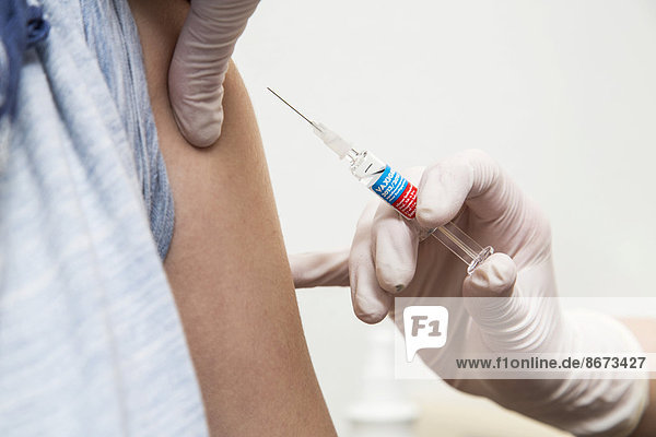 Junge Frau bekommt eine Grippeschutzimpfung  Vaxigrip  Deutschland