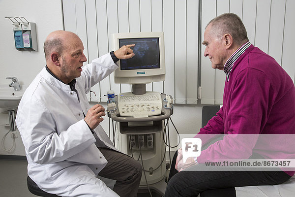 Medical practice  internist talking to an elderly patient about images from a sonographic scanner  Germany