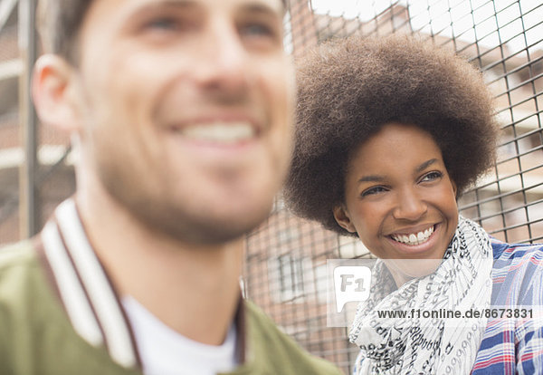 Man and woman smiling near fence