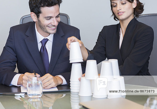 Geschäftsleute stapeln Tassen im Meeting