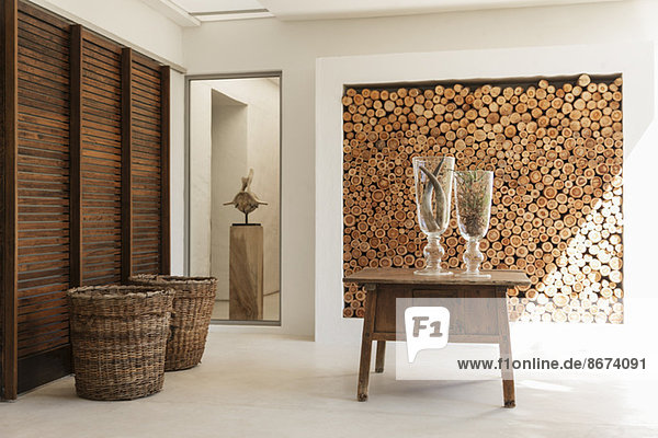 Holzscheite in Wand und Tisch im modernen Foyer