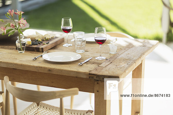 Wein und Aperitif auf Holztisch auf Terrasse
