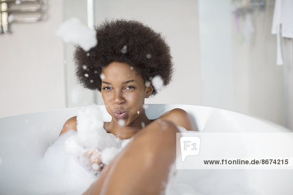 Frau spielt mit Blasen im Bad
