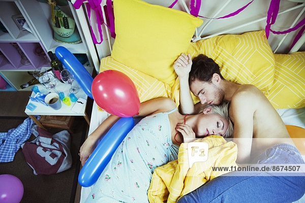 Couple sleeping in bed after party