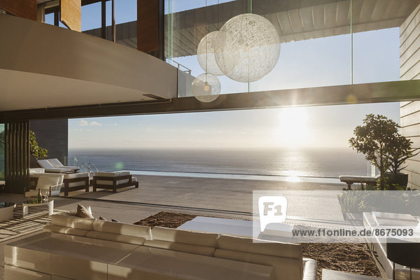 Modernes Wohnzimmer mit Blick auf das Meer bei Sonnenuntergang