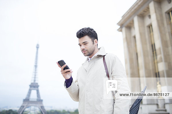 Geschäftsmann mit Handy von Eiffelturm  Paris  Frankreich