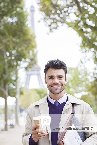 Geschäftsmann lächelt im Park beim Eiffelturm  Paris  Frankreich