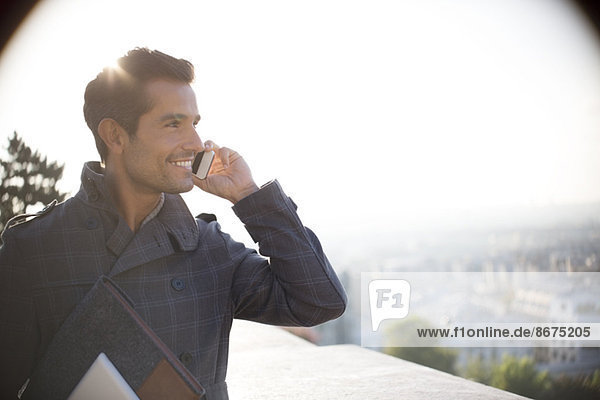 Businessman on cell phone overlooking city