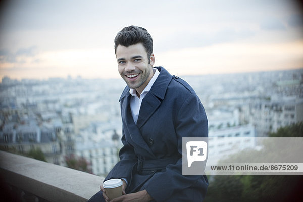 Geschäftsmann beim Kaffeetrinken auf dem Sims mit Blick auf Paris  Frankreich