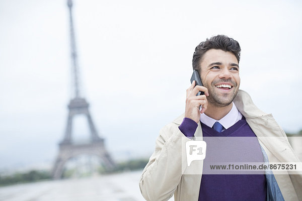 Geschäftsmann im Gespräch am Handy am Eiffelturm