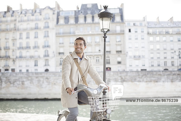 Businessman on bicycle along Seine River  Paris  France