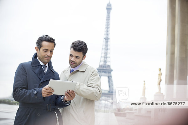 Geschäftsleute mit digitalem Tablett am Eiffelturm,  Paris,  Frankreich
