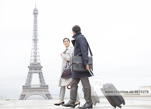 Business people with suitcases passing by Eiffel Tower  Paris  France
