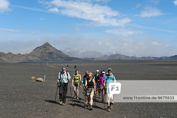 Trekking im Hochland  Wandergruppe geht über vegetationslose Schotterfläche  Trekkingweg Laugavegur  hinten Berg Storasula  bei Emstrur  Rangárþing ytra  Suðurland  Island  Skandinavien