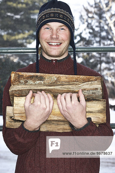 Feuerholz Europäer Mann tragen Schnee
