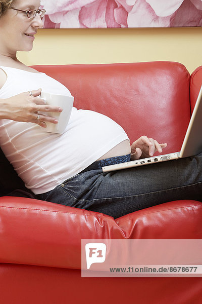 benutzen Europäer Frau Notebook Couch Schwangerschaft