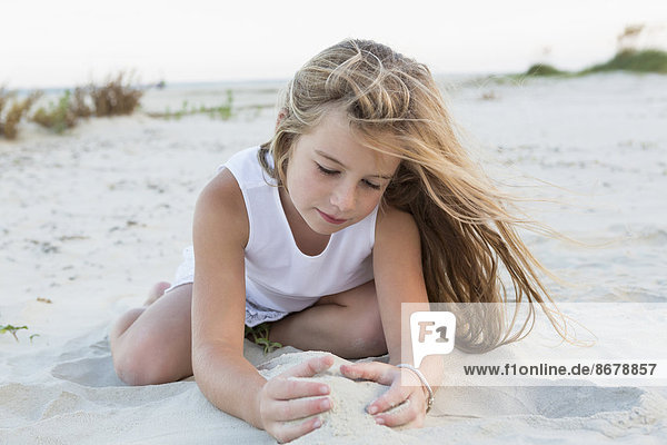 Girl playing in sand on beach