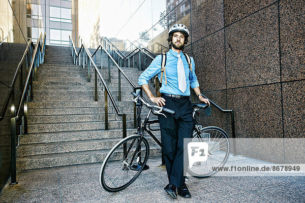Caucasian businessman with bicycle on urban stairs