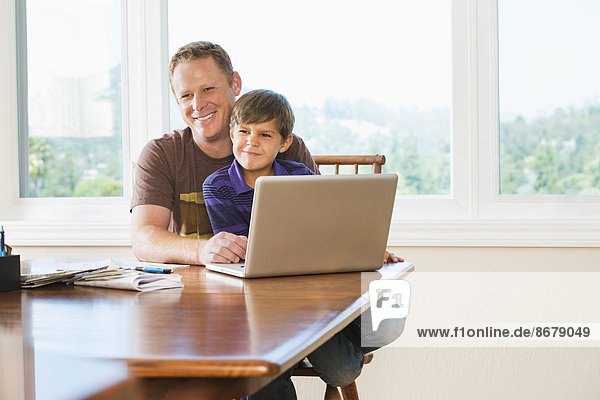 Father and son using laptop together