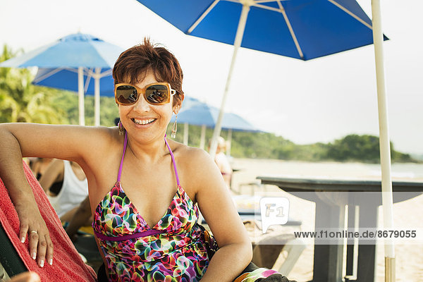 Hispanic woman smiling in lounge chair