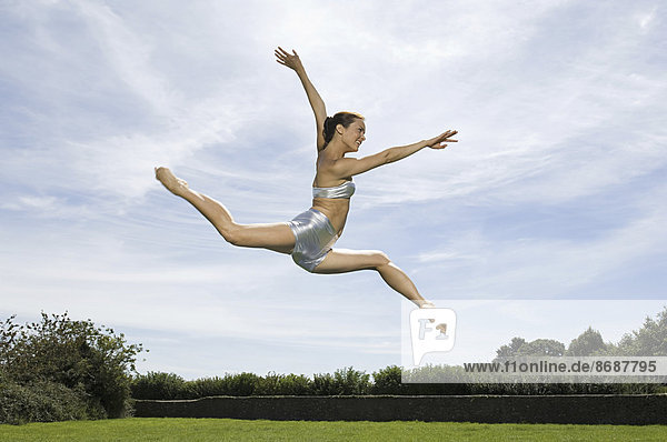 Eine junge Frau springt in die Luft. Akrobat.