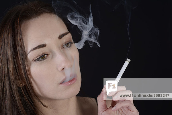 Porträt einer jungen Frau mit Zigarettenstäube