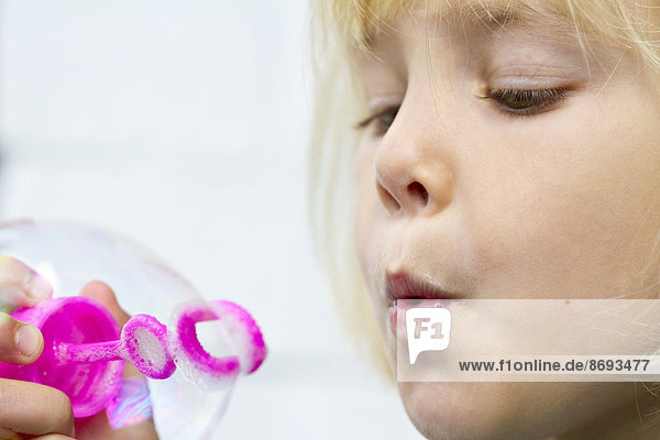 Porträt eines kleinen Mädchens  das Seifenblasen macht