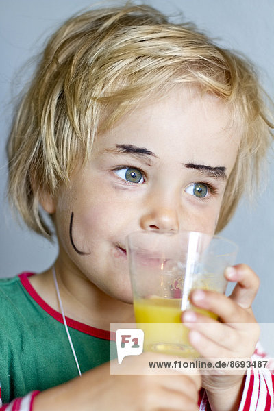 Portrait of little girl drinking fruit juice