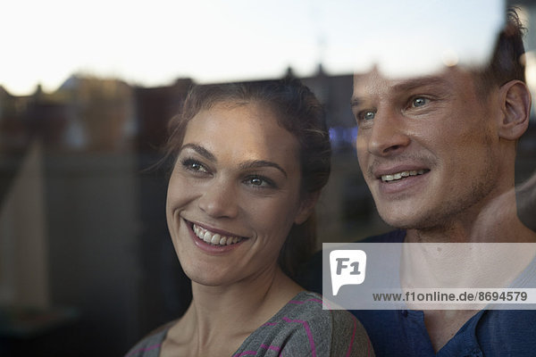 Lächelndes Paar hinter dem Fenster