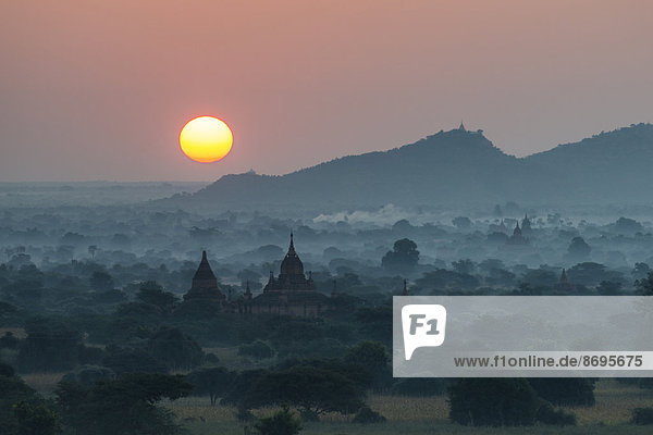 Sunrise temples in the morning mist stupas and pagodas in the temple complex of the Plateau of Bagan Mandalay Division Myanmar or Burma