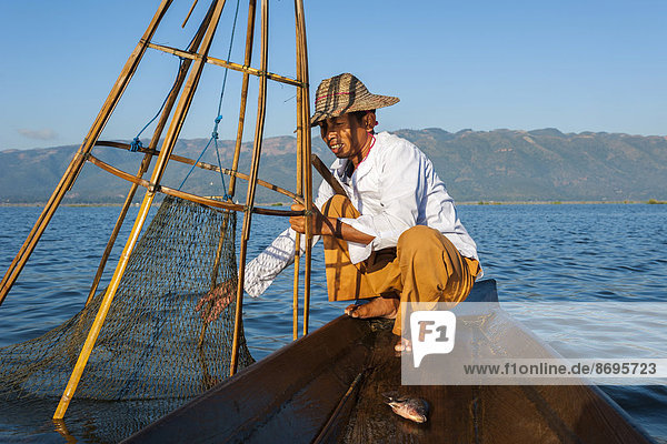 Fischer mit traditionellem Korb  gefangener Fisch im Kanu  Inle-See  Shan-Staat  Myanmar