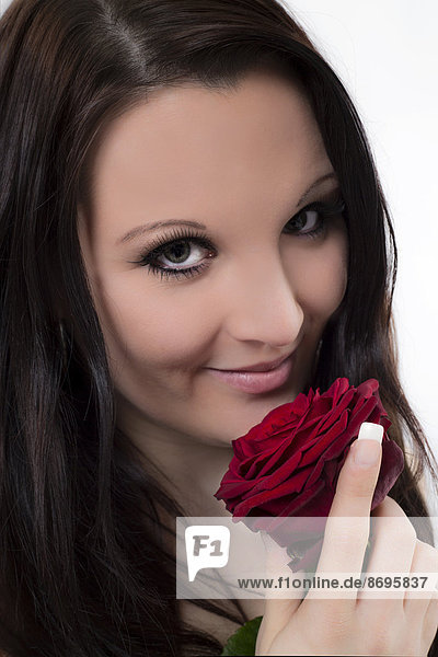 Lächelnde junge Frau mit roter Rose