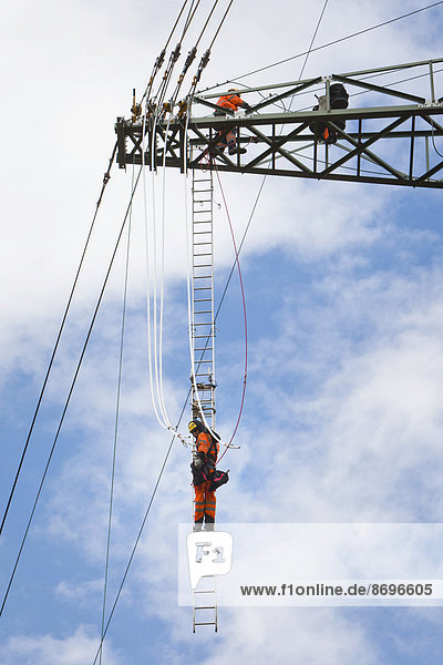 Freileitungsmonteure bei Leiterseilzugarbeiten auf der Traverse eines neu errichteten Höchstspannungsmastes,  Mönchenholzhausen,  Thüringen,  Deutschland