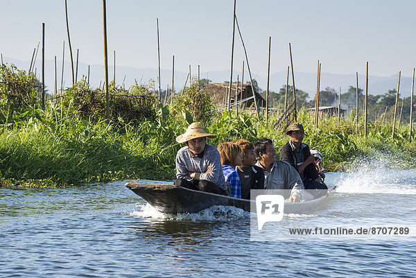 People in a canoe floating garden field on the water Inle Lake Shan State Myanmar