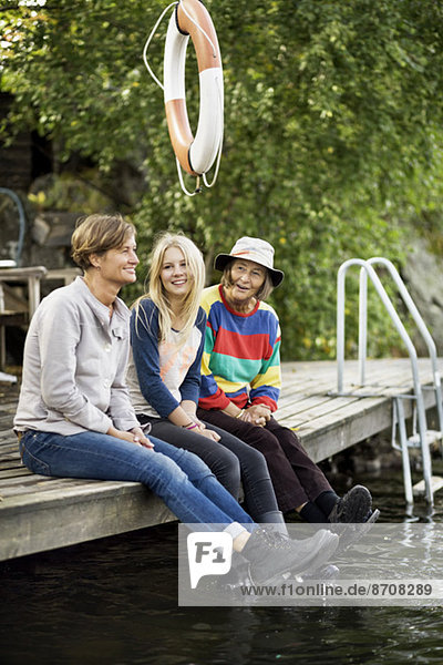 Drei Generationen Weibchen sitzen auf dem Pier