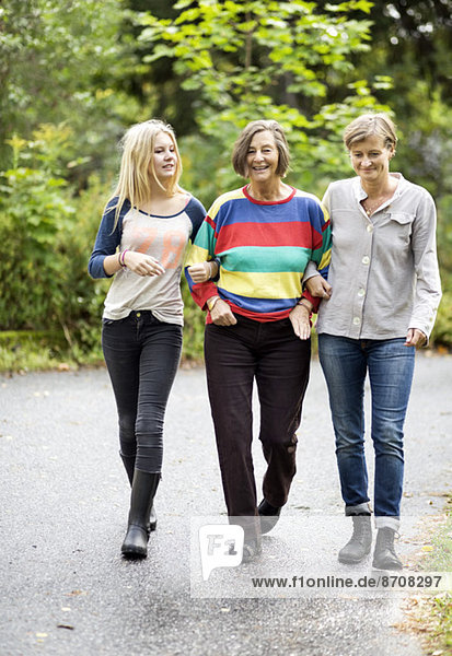 Three generation females walking on street