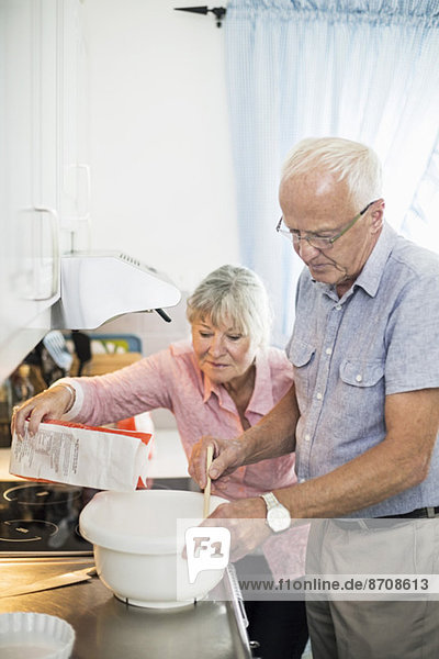 Senior couple preparing food at kitchen counter