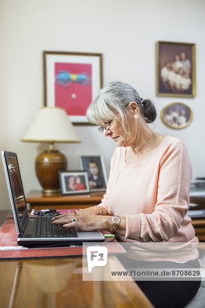 Senior Frau mit Laptop zu Hause