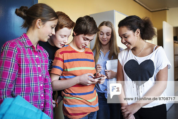 Gymnasiasten nutzen Handy im Umkleideraum