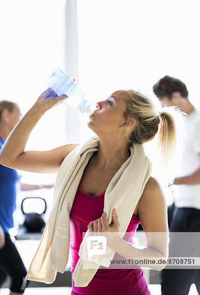 Fit junge Frau Trinkwasser im Fitnessstudio