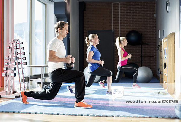 People exercising with kettlebells at gym