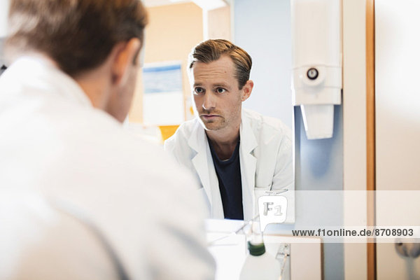 Spiegelbild des männlichen Arztes im Krankenhausbad