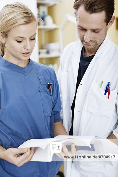 Doctor and nurse reading file in hospital