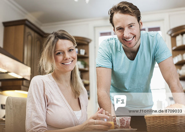 Porträt des glücklichen mittleren Erwachsenenpaares in der Küche