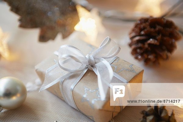Weihnachtstisch mit Geschenk  Lichtern und Tannenzapfen