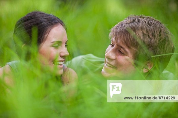 Junges Paar im langen Gras liegend