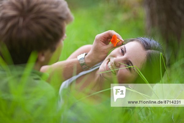 Junger Mann mit Blume im Haar der Frau
