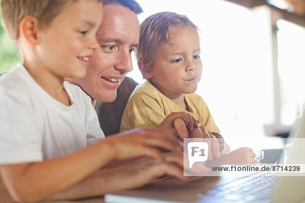 Vater und Söhne mit Laptop